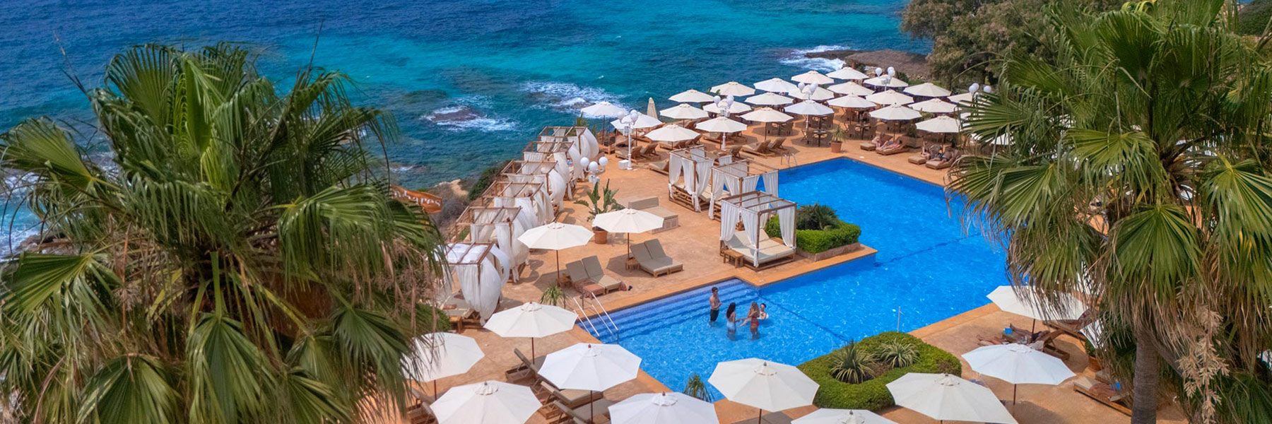 Mhares Sea Club: Vista panorámica con piscina y terrazas sobre el Mediterráneo al atardecer en Mallorca.